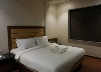Comfortable bed in a deluxe room at Chattarpur Farms in Nagpur