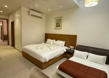 Deluxe room with beds and seating area at Chattarpur Farms in Nagpur
